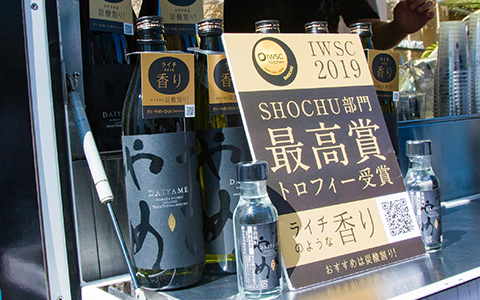 写真：だいやめの瓶とIWSC2019 SHOCHU部門最高賞トロフィー受賞の告知パネル